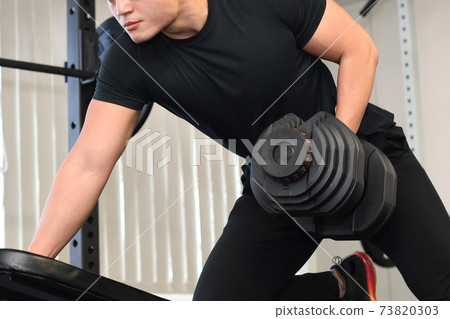 Men training in the gym (one-handed rowing) Men training in the gym (one-handed rowing) 73820303