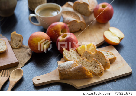 French bread baguette cut on wooden board with knife. with a chocolate butter French bread baguette cut on wooden board with knife. with a chocolate butter 73821675