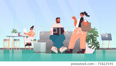 businesspeople working and talking together in coworking center business meeting teamwork concept 73822545