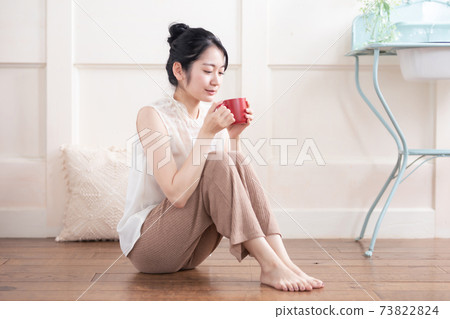 Woman drinking hot drink in the room Woman drinking hot drink in the room 73822824