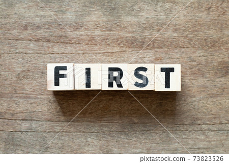 Alphabet letter block in word first on wood background Alphabet letter block in word first on wood background 73823526