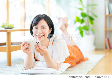 A young woman watching a video on her smartphone A young woman watching a video on her smartphone 73824857