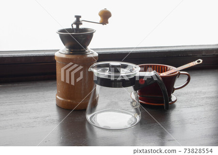 Kitchen utensils such as mills, glass servers and drippers needed to brew coffee on the windowsill 73828554