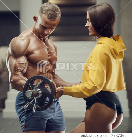 Sporty fitness couple working out in gym Sporty fitness couple working out in gym 73828621