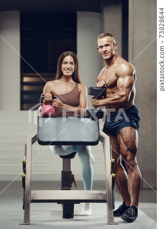 Sporty fitness couple working out in gym 73828644