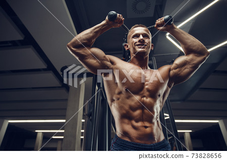 Caucasian man pumping up muscles. fitness training Caucasian man pumping up muscles. fitness training 73828656