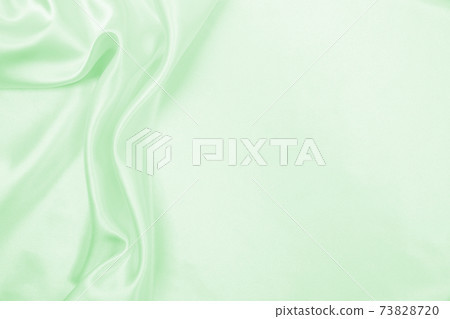 Smooth elegant green silk or satin luxury cloth texture as abstract background. Luxurious background design 73828720