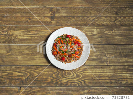 Salad with buckwheat and vegetables on a white plate Salad with buckwheat and vegetables on a white plate 73828781