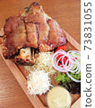 Fried pork leg drumstick, knee of a wild boar with vegetables of onion, garlic, parsley and basil on a wooden background. Prague. 73831055