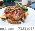 Grilled steaks, baked potatoes. herbs and vegetables,Prague. 73831057