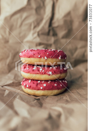 Fresh raspberry donuts on crumpled craft paper Fresh raspberry donuts on crumpled craft paper 73831077