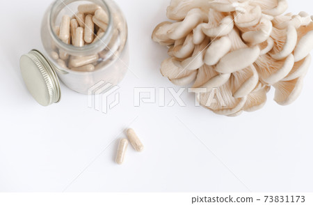 mushrooms and a bottle with mushroom capsules supplement mushrooms and a bottle with mushroom capsules supplement 73831173