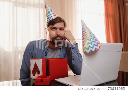 young man sitting at the table and talking by video call to friends. young man sitting at the table and talking by video call to friends. 73831965