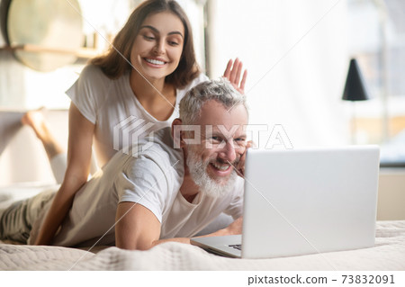 Man behind laptop and woman who distracts him Man behind laptop and woman who distracts him 73832091