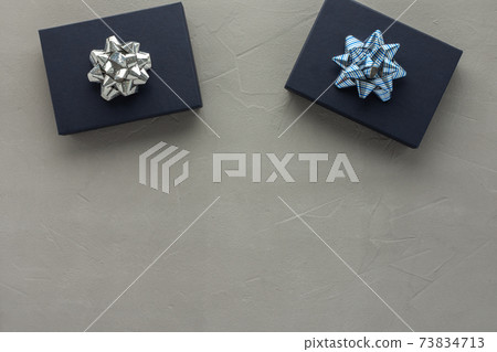 Blue gift boxes with a bow on a gray concrete background 73834713