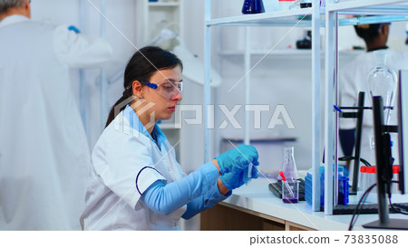 Woman scientist filling liquid test tube with pipette Woman scientist filling liquid test tube with pipette 73835088