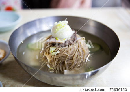 Pyongyang cold noodles with beef, boiled egg, and broth in a soba sari, traditional Korean food Pyongyang cold noodles with beef, boiled egg, and broth in a soba sari, traditional Korean food 73836150