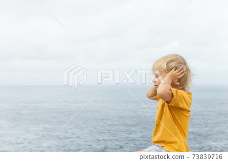 Face portrait of annoyed, unhappy caucasian child grabbed head 73839716
