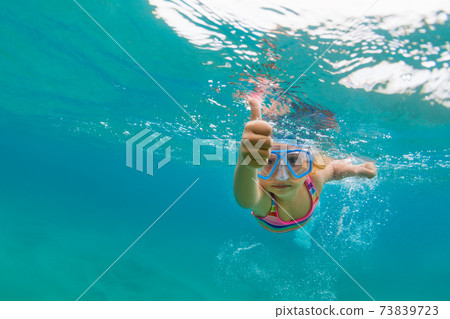 Young girl diving underwater Young girl diving underwater 73839723