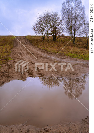 A muddy puddle and a dirt road at a moor. Picture from Revingehed, Scania, Sweden 73840038