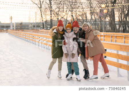 Happy family on ice rink Happy family on ice rink 73840245