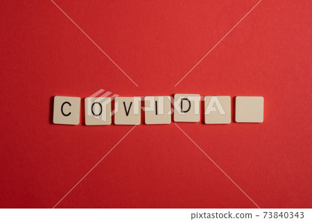 Covid-19 words on a red background. Copy space. 73840343