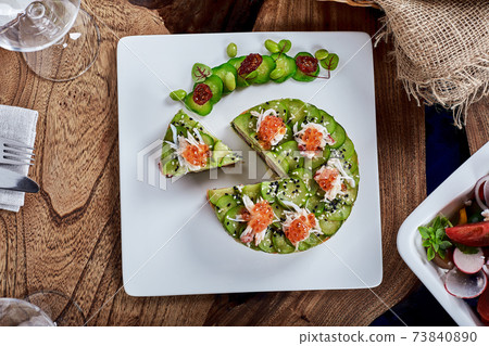Salad of avokado, seafood, meat, vegetables and pumpkin seeds. Dietary, wholesome and tasty. Banquet festive dishes. Gourmet restaurant menu. White background. 73840890