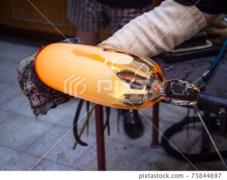 Glass artis shaping manualy big hot glass piece on glassblowing whistle Glass artis shaping manualy big hot glass piece on glassblowing whistle 73844697