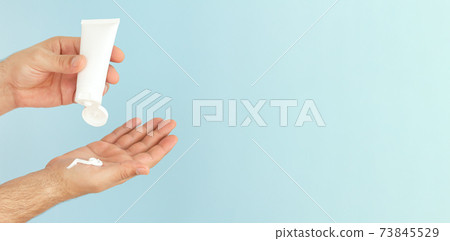 Male hands apply cosmetic skin care moisturizer cream or ointment 73845529