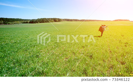 promiscuous man with a chair on his shoulder goes into the distance on the boundless green field 73846122