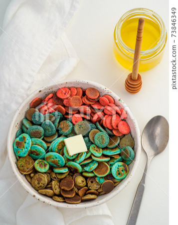 Colorful pancake cereal in baby hands 73846349