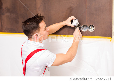 The electrician is fixing electrical wires for wall socket The electrician is fixing electrical wires for wall socket 73847741