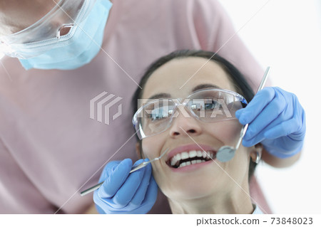 Woman demonstrates her teeth at dentist appointment Woman demonstrates her teeth at dentist appointment 73848023