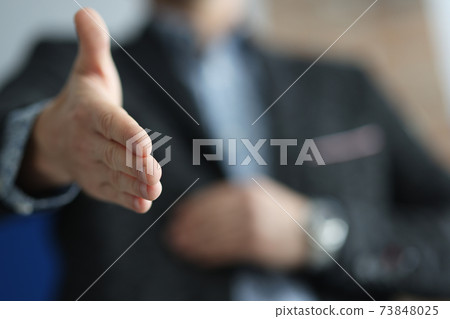 Man in suit stretches out here for handshake Man in suit stretches out here for handshake 73848025