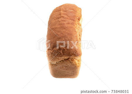 Whole loaf of wheat bread on a white plate. 73848031
