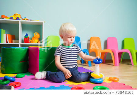 the adorable boy is building pyramid with colored hoops blocks the adorable boy is building pyramid with colored hoops blocks 73848165