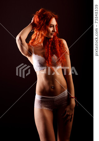 Sexy woman in lingerie in black background, red hair Sexy woman in lingerie in black background, red hair 73848339