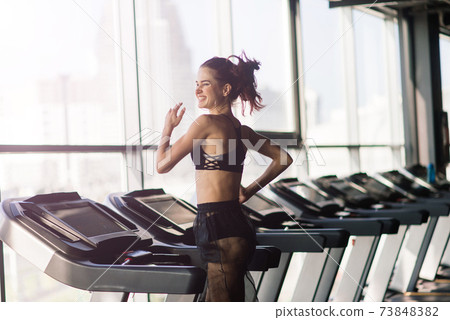 Young woman exercise fitness and workout while run on track in sport club 73848382