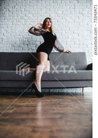 Young sexy blonde with naked legs in high heel shoes posing near the sofa Young sexy blonde with naked legs in high heel shoes posing near the sofa 73848471