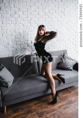 Young sexy blonde with naked legs in high heel shoes posing near the sofa Young sexy blonde with naked legs in high heel shoes posing near the sofa 73848485