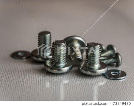 Iron screws and washers on the reflective surface 73849480