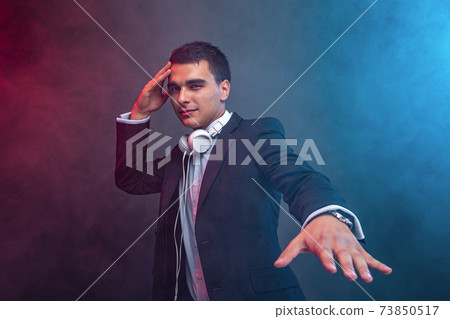 Portrait of man with headphones on dark background with smoke. Studio shoot Portrait of man with headphones on dark background with smoke. Studio shoot 73850517