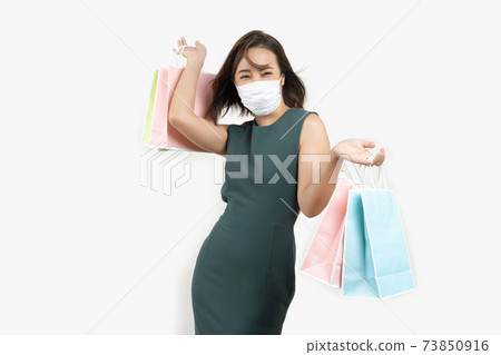 Young Asian woman holding shopping bag wear face mask Young Asian woman holding shopping bag wear face mask 73850916