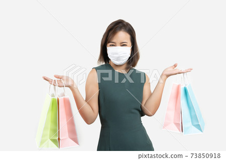 Young Asian woman holding shopping bag wear face mask Young Asian woman holding shopping bag wear face mask 73850918