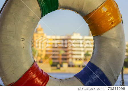 old lifebuoy hanging on the building background 73851996