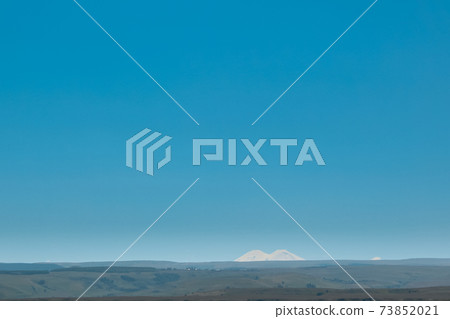 double peak of Elbrus in the distance against the blue sky. Russia, Caucasus double peak of Elbrus in the distance against the blue sky. Russia, Caucasus 73852021