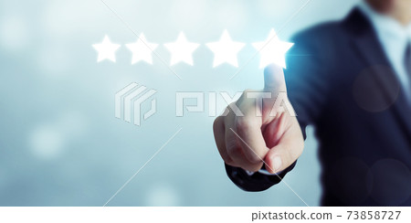 Businessman pointing five star symbol to increase rating of company 73858727