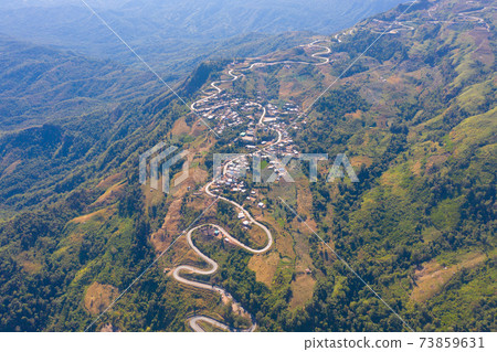 Aerial view of cars driving on curved, zigzag curve road or street on mountain hill with green natural forest trees in rural area of Phu Tub Berk, Phetchabun, Thailand. Aerial view of cars driving on curved, zigzag curve road or street on mountain hill with green natural forest trees in rural area of Phu Tub Berk, Phetchabun, Thailand. 73859631