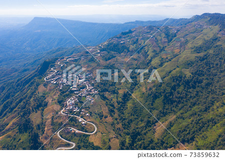Aerial view of cars driving on curved, zigzag curve road or street on mountain hill with green natural forest trees in rural area of Phu Tub Berk, Phetchabun, Thailand. Aerial view of cars driving on curved, zigzag curve road or street on mountain hill with green natural forest trees in rural area of Phu Tub Berk, Phetchabun, Thailand. 73859632