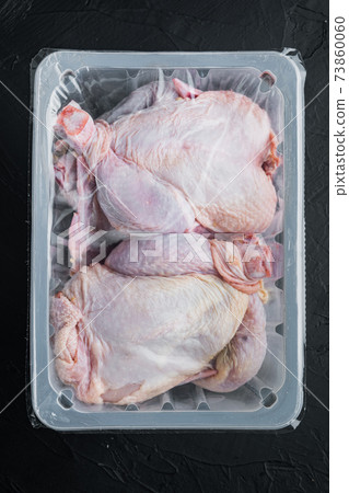 Plastic container with raw chicken, on black background, top view Plastic container with raw chicken, on black background, top view 73860060